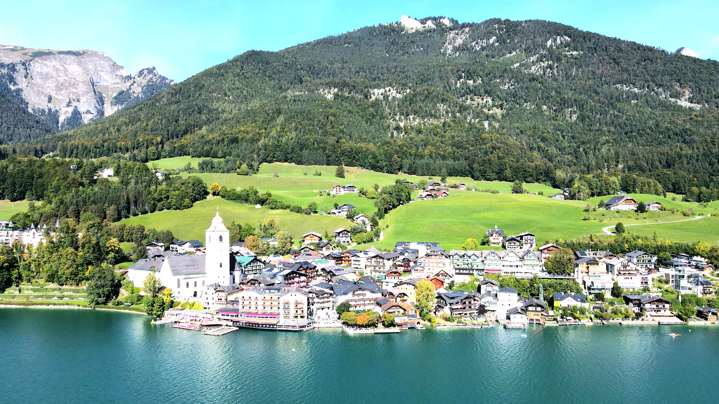 Wolfgangsee mit Uferort, Wohnhäusern und umliegenden Bergen